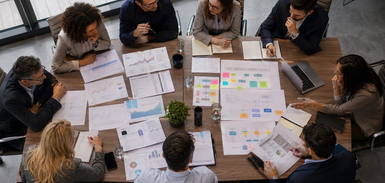 Cross-functional leadership team reviewing SEO reports, operational workflows, project roadmaps, and resource planning during an executive workshop focused on improving organizational alignment and search performance.